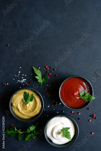Set of popular sauces in a black bowls. Top view with copy space.