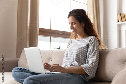 Happy attractive young woman using computer.