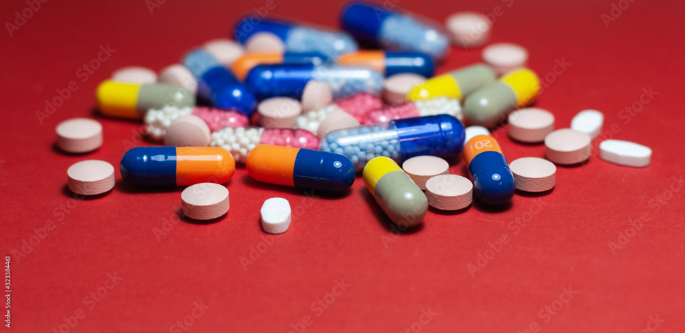 Heap of pills, tablets, capsules on red background. Drug prescription for treatment medication health care concept wth copy space. Heap of pills, tablets, capsules on red background. Drug prescription for treatment medication health care concept wth copy space.