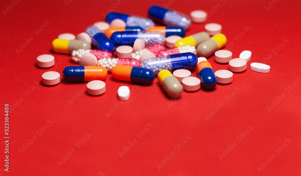 Heap of pills, tablets, capsules on red background. Drug prescription for treatment medication health care concept wth copy space. Heap of pills, tablets, capsules on red background. Drug prescription for treatment medication health care concept wth copy space.