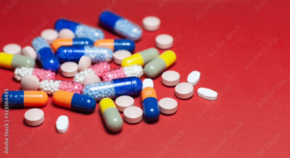 Heap of pills, tablets, capsules on red background. Drug prescription for treatment medication health care concept wth copy space. Heap of pills, tablets, capsules on red background. Drug prescription for treatment medication health care concept wth copy space.