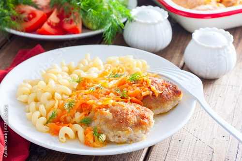 Baked homemade meat patties with pasta on a white plate, selective focus