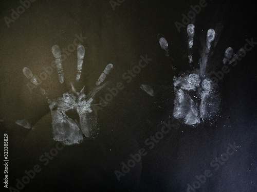 Five fingers hand mark from loose powder on a black background