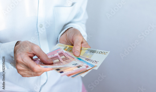 Female woman hand holds out a pack of euro close up, finance business concept.