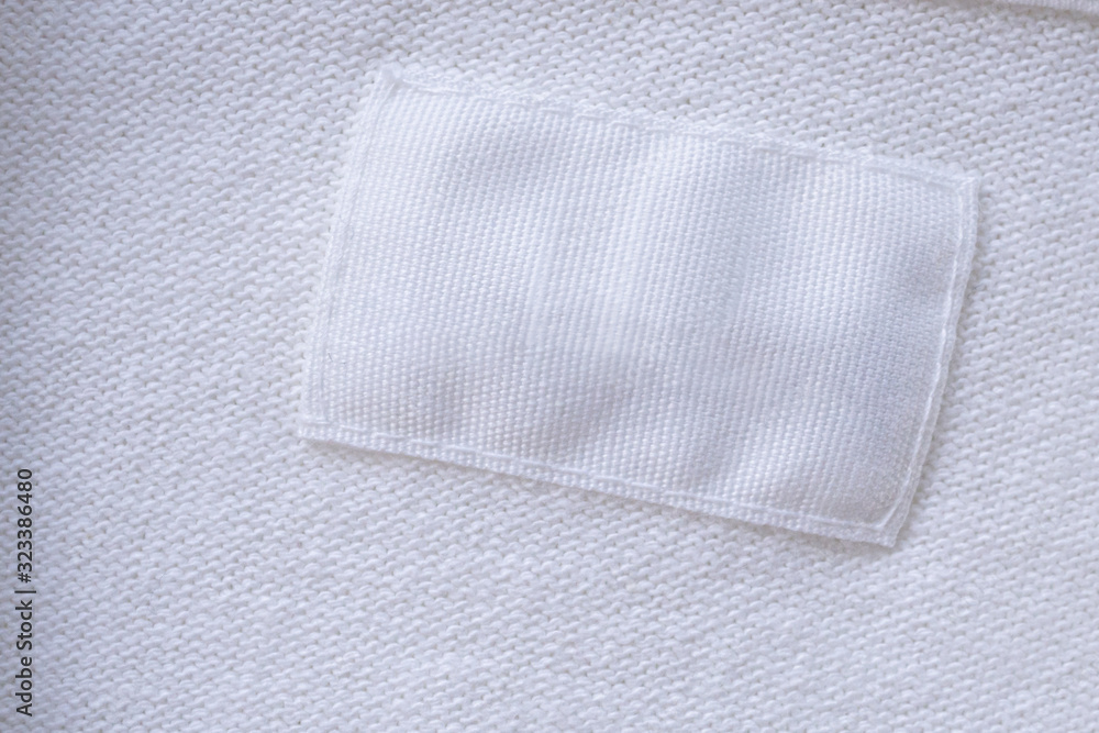 Blank white clothes label on new shirt background Blank white clothes label on new shirt background