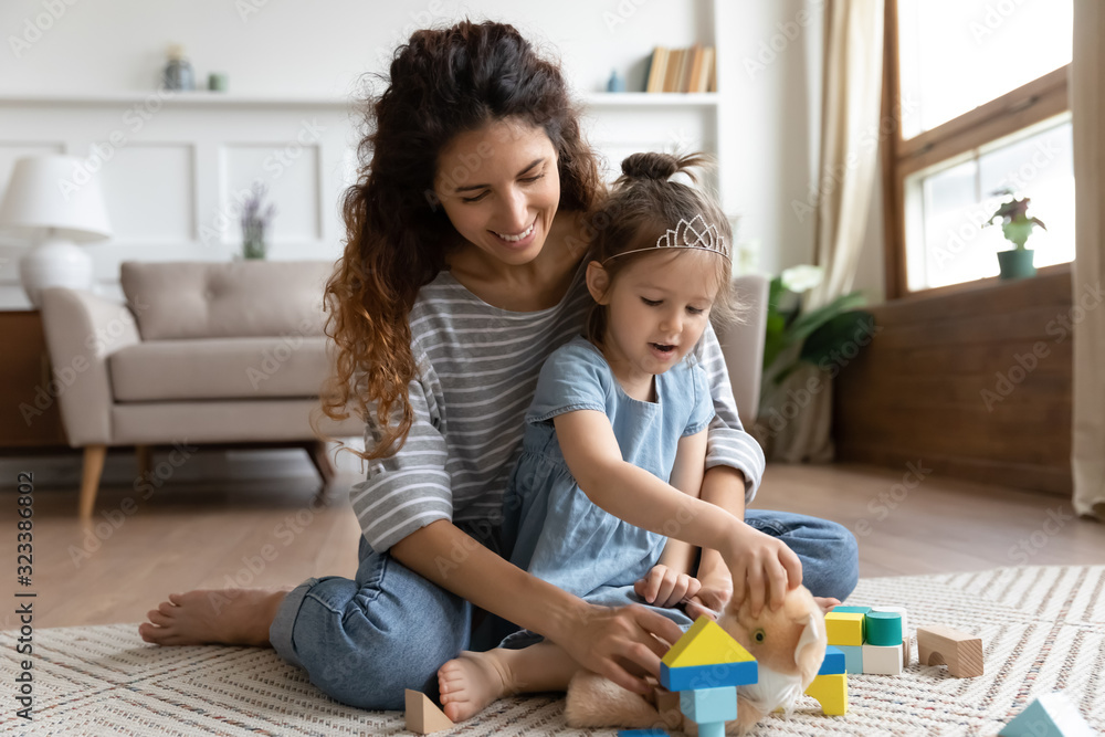 Obraz premium Smiling nanny having fun with child at home.