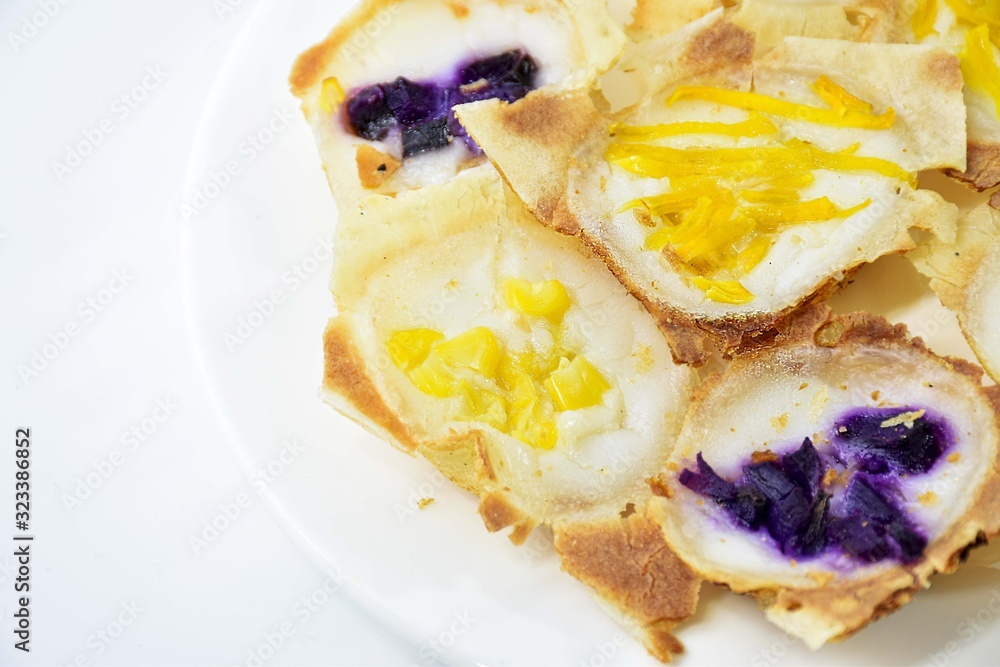 khanom khrok,Thailand desserts made from coconut milk, filled with a lilac pumpkin in a white plate. khanom khrok,Thailand desserts made from coconut milk, filled with a lilac pumpkin in a white plate.
