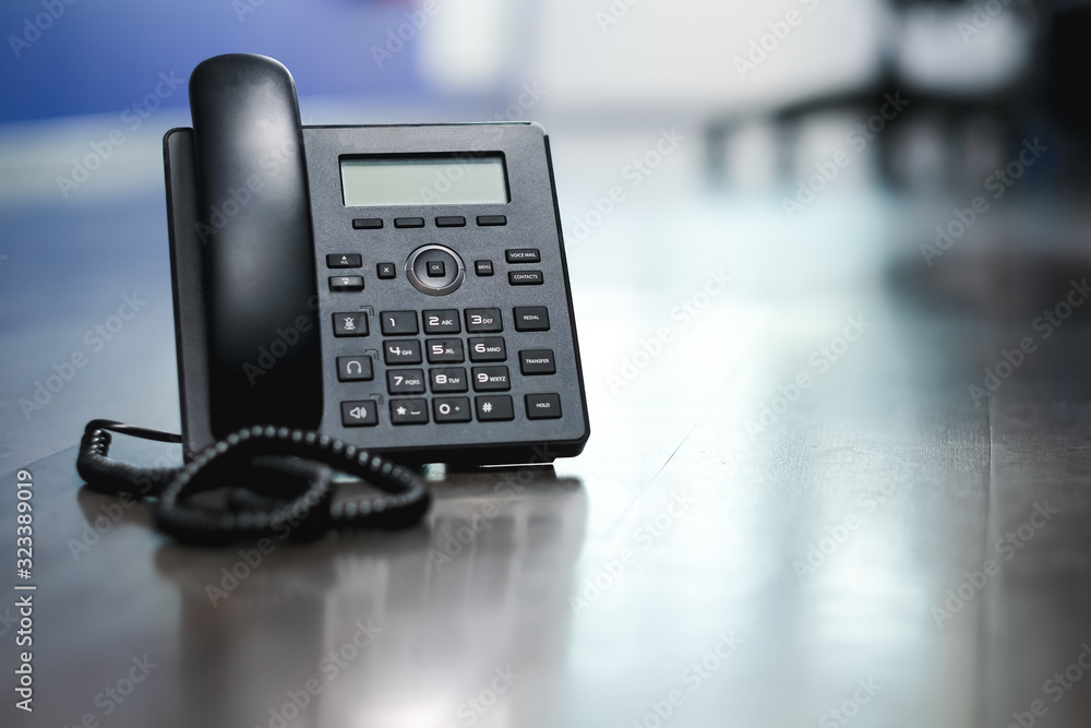 Close Up Black ip phone is placed on a wooden floor in the office. Close Up Black ip phone is placed on a wooden floor in the office.