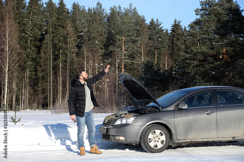Man stands outdoor near broken car Man stands outdoor near broken car