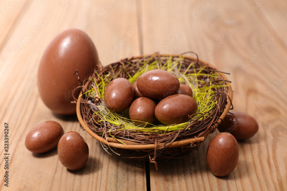 chocolate egg in nest on wood background chocolate egg in nest on wood background