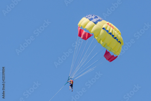 Parasailing on blue sky background. Parachute in the sky
