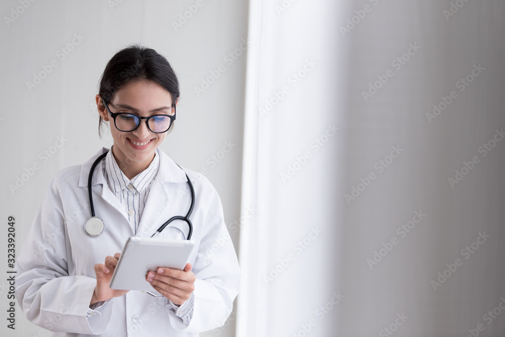 A doctor woman has to work with touching the tablet at the hospital with smiling and happiness. A doctor woman has to work with touching the tablet at the hospital with smiling and happiness.