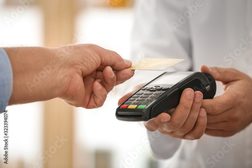 Cuadro en lienzo Customer using terminal for contactless payment with credit card in pharmacy, cl