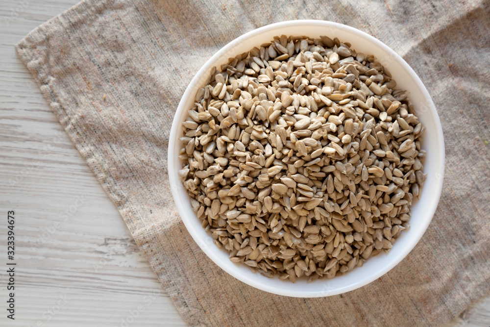 Raw Organic Sunflower Seed Kernels in a white bowl, overhead view. Flat lay, top view, from above. Raw Organic Sunflower Seed Kernels in a white bowl, overhead view. Flat lay, top view, from above.