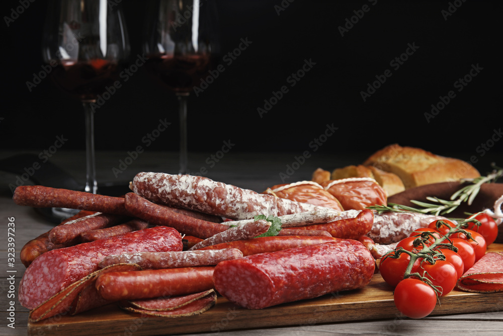 Different tasty sausages on wooden table, closeup
