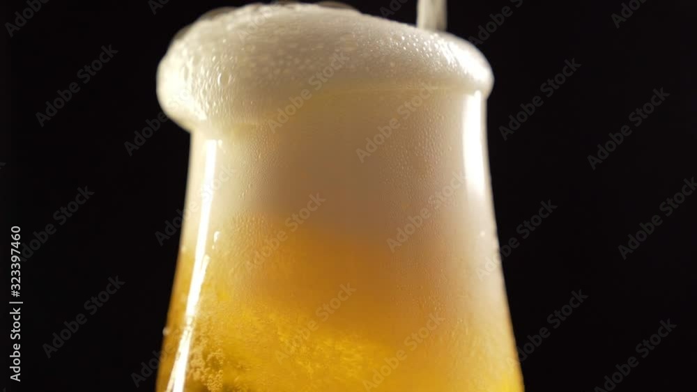 Beer poured into glass and it foams and overflows Stock ビデオ Adobe Stock