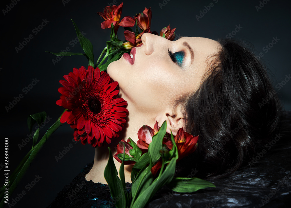 Beauty portrait of a woman with beautiful evening makeup and flowers on her face, a brunette girl in a shiny evening dress with sequins. Natural face cosmetics, flower petals Beauty portrait of a woman with beautiful evening makeup and flowers on her face, a brunette girl in a shiny evening dress with sequins. Natural face cosmetics, flower petals