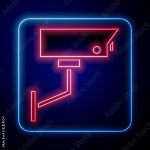 Glowing neon Security camera icon isolated on blue background. Vector Illustration