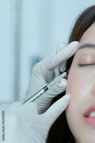 Fototapeta Naklejka Na Ścianę i Meble -  Botox, Filler injection for Asian female face. Plastic aesthetic facial surgery in beauty clinic.