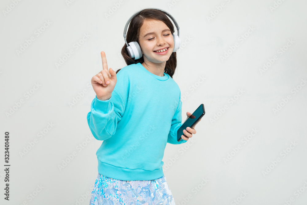 girl in a turquoise blouse relaxes with music in headphones girl in a turquoise blouse relaxes with music in headphones