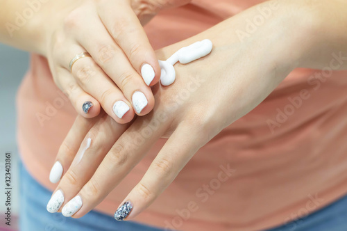 a woman puts cream on her hands. close up