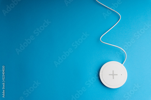 Charging pad or dock on blue background.Wireless charging and copy space