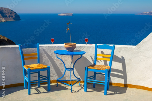 Two Glasses and Two Chairs on a Sunny Rocky Shore