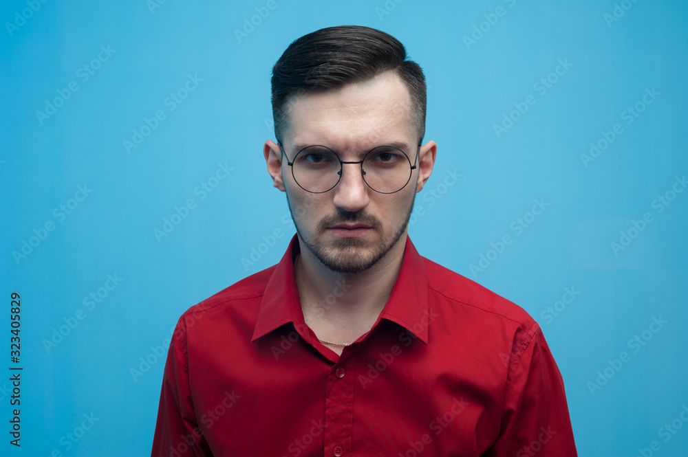Fototapeta premium Young man in glasses and a burgundy shirt
