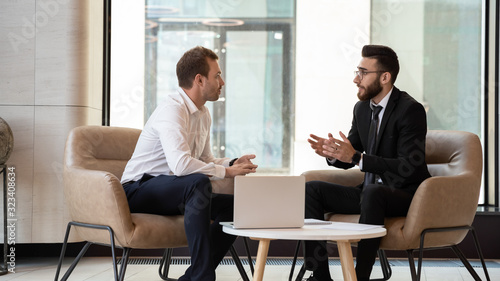 Fotografia Middle eastern and caucasian ethnicity businessmen talking negotiating indoors