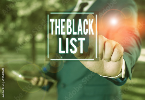 Handwriting text writing TheBlack List. Conceptual photo list of demonstratings who are disapproved of or are to be punished Businessman with pointing finger in front of him photo