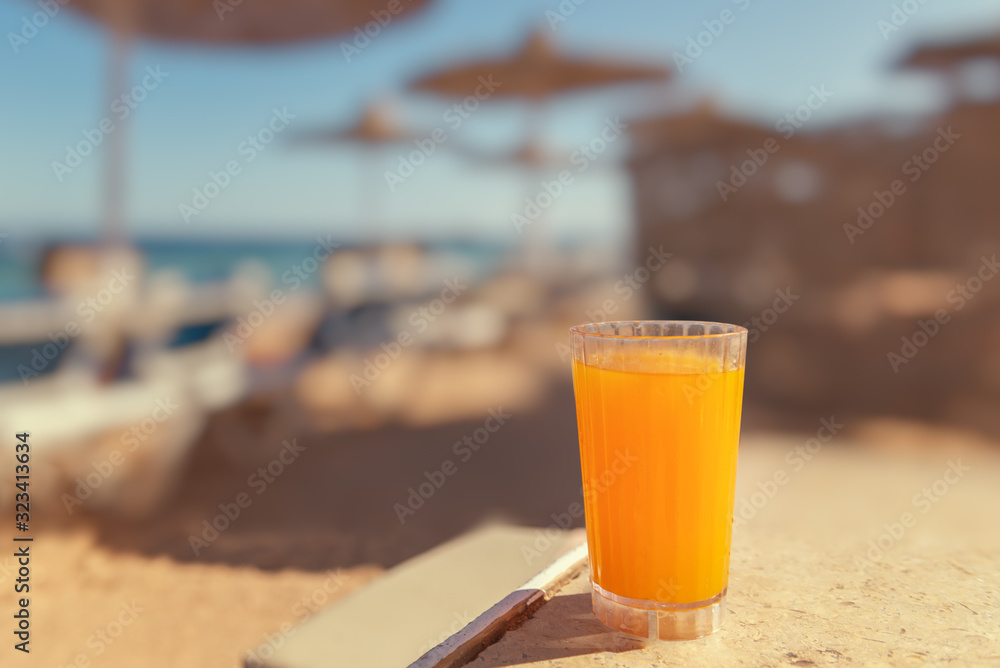 Mango juice in a glass on the beach Mango juice in a glass on the beach