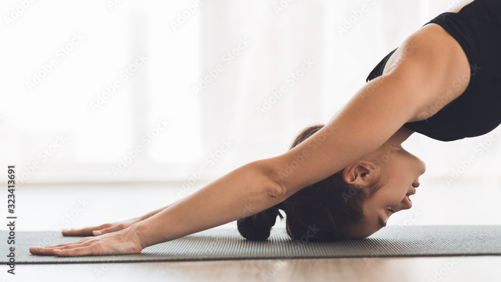 Woman stretching in child pose at modern studio Woman stretching in child pose at modern studio