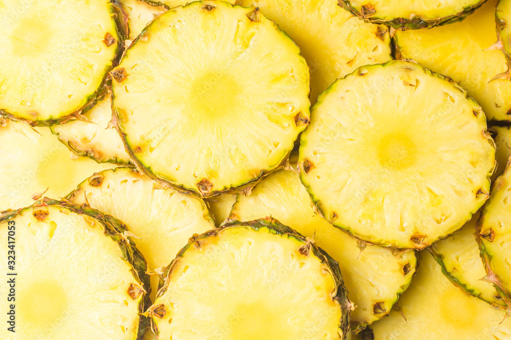 Pineapple juicy yellow slices background. Top view.