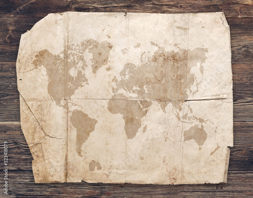 Old grunge world map on the wooden background