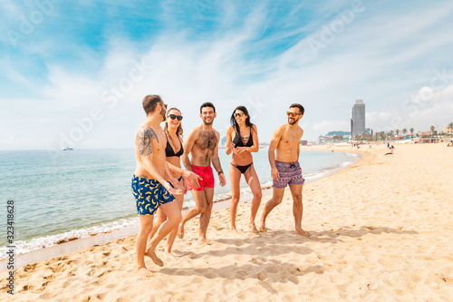 Happy friends having fun on the beach in Barcelona