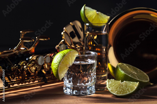 Canvas Print Saxophone and tequila with lime on a wooden table.