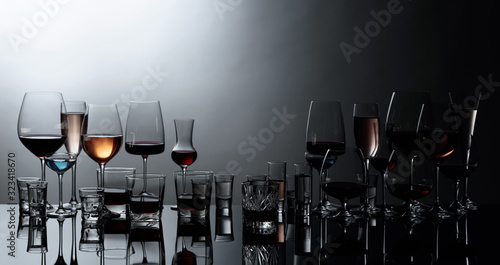 Foto Various alcoholic beverages in glasses on a black reflective background