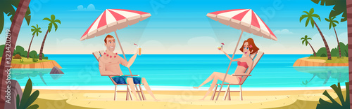 Happy couple sitting on the deck chairs at the seaside under palm trees.