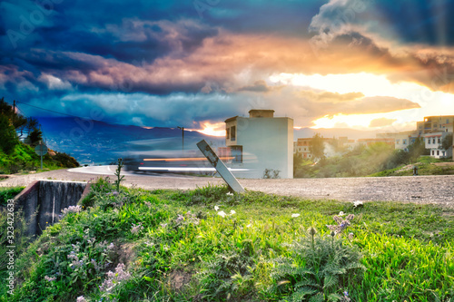 Canvas Print Car moving on a road in Chefchaouen (Morocco) with a dramatic sunset in the back