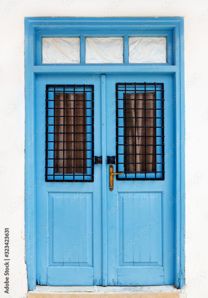 Fototapeta premium Beautiful old blue door. Fragment of the facade of the house, Cyprus, Europe.