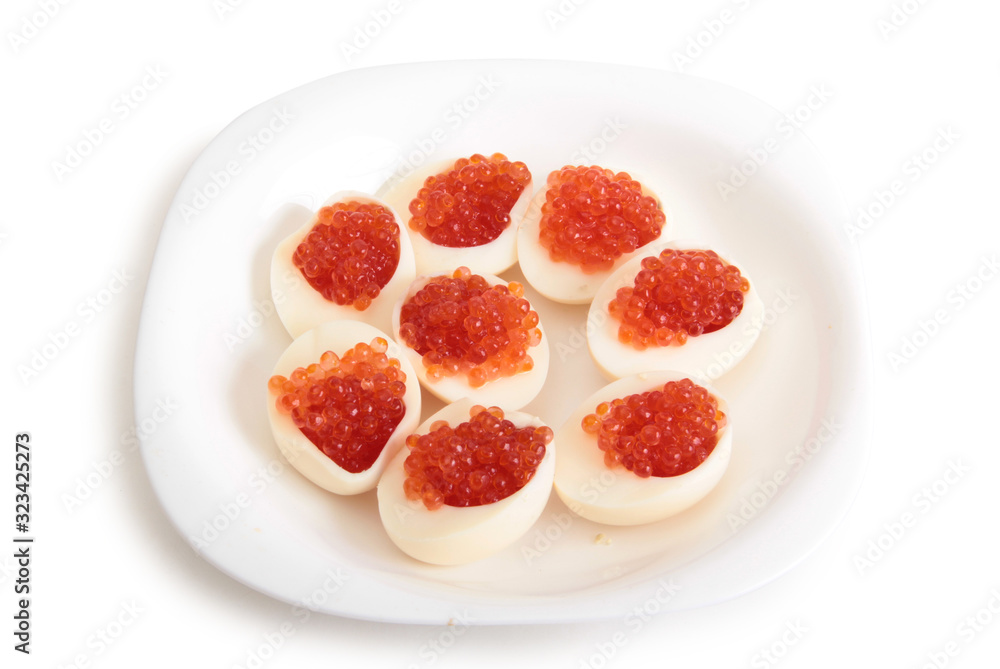 Red caviar on boiled chicken egg. Isolated object on a white background Red caviar on boiled chicken egg. Isolated object on a white background