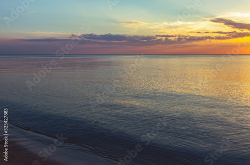 Beautiful, colorful sunset on the shore of the Baltic Sea on a warm summer evening. Colorful skies and clouds