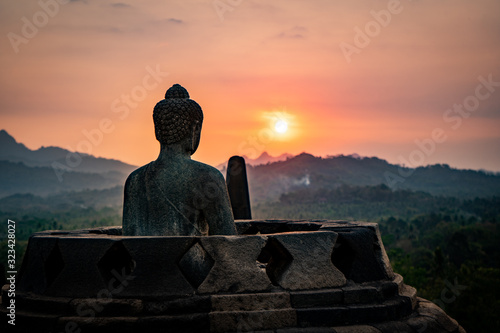 buddha statue at sunset borobodur indonesia photo