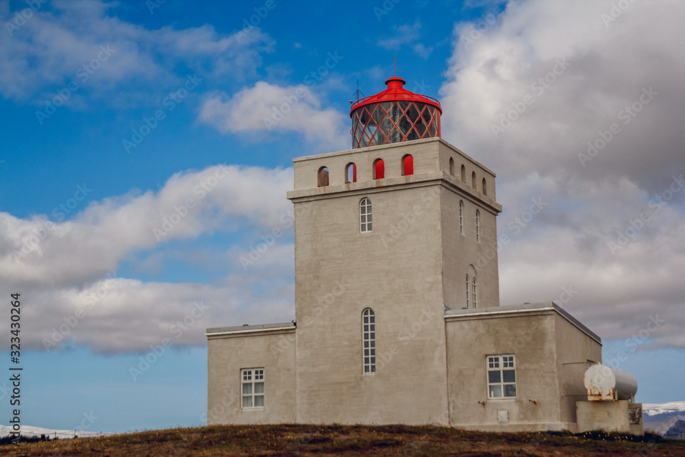 Lighthouse at Dyrholaey Cape in South Iceland on beautiful sky background. Place for text or advertising