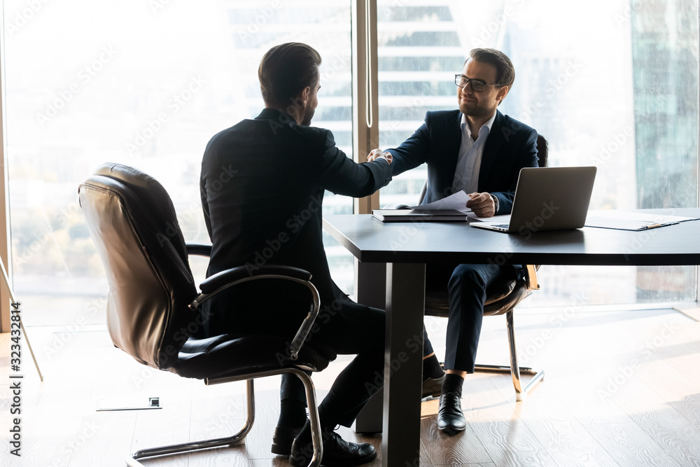 Happy bearded businessman in suit shaking hands with job seeker. Happy bearded businessman in suit shaking hands with job seeker.