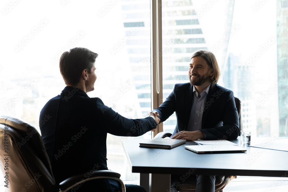 Bearded businessman in suit shaking hands with job seeker. Bearded businessman in suit shaking hands with job seeker.