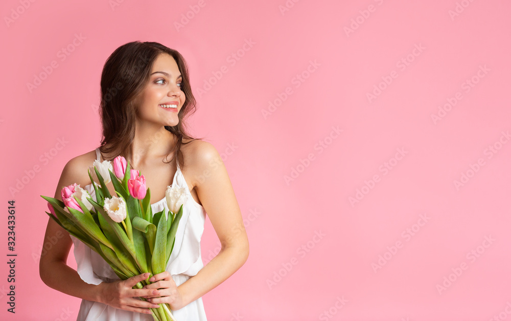 Portrait of happy beautiful woman with tulip flowers bouquet in hands