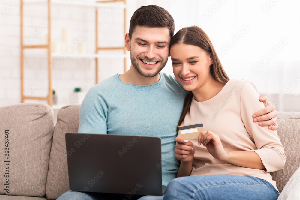 Couple Using Laptop And Credit Card Shopping Online At Home Couple Using Laptop And Credit Card Shopping Online At Home