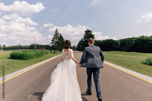 bride and groom running along the road forward