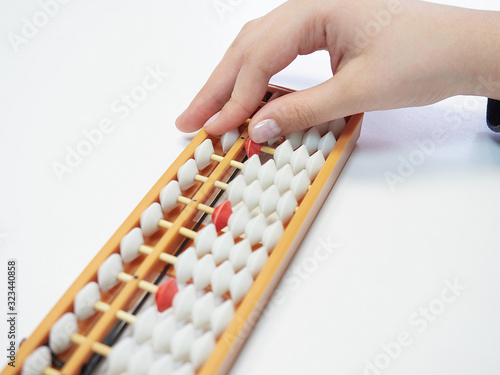 Classes in mental arithmetic  hands and abacus soroban on white background. closeup